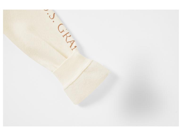 Ein cremefarbener Pullover mit braunem Logo.