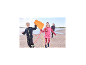 Kinder laufen mit einem Drachen am Strand, gekleidet in CRIVIT Funktionstights.