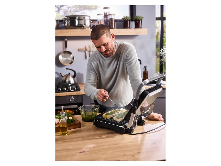 Ein Mann bereitet Essen auf dem SILVERCREST® Kontaktgrill SKG 2000 F1 zu.