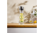 Glaskaraffe mit Zitronenwasser und ein Glas auf einer Holztheke.
