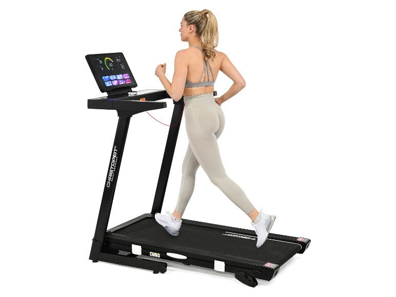 Junge Frau läuft auf einem Laufband mit Touchscreen-Display, in grauer Sportkleidung.
