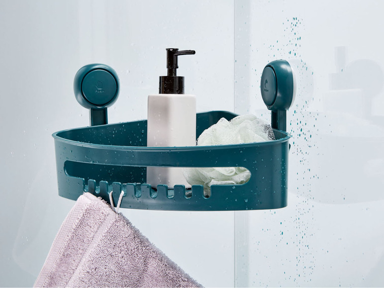Ein grünes Eckregal mit Saugnäpfen in einer Dusche, mit Shampoo, einem Schwamm und einem Handtuch.