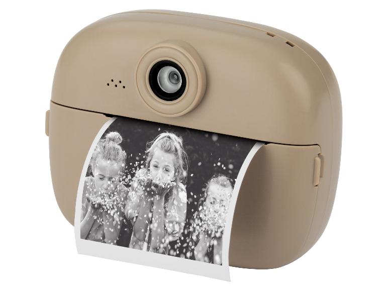 Beige Sofortbildkamera mit einem ausgedruckten Foto von drei Mädchen, die Konfetti pusten.