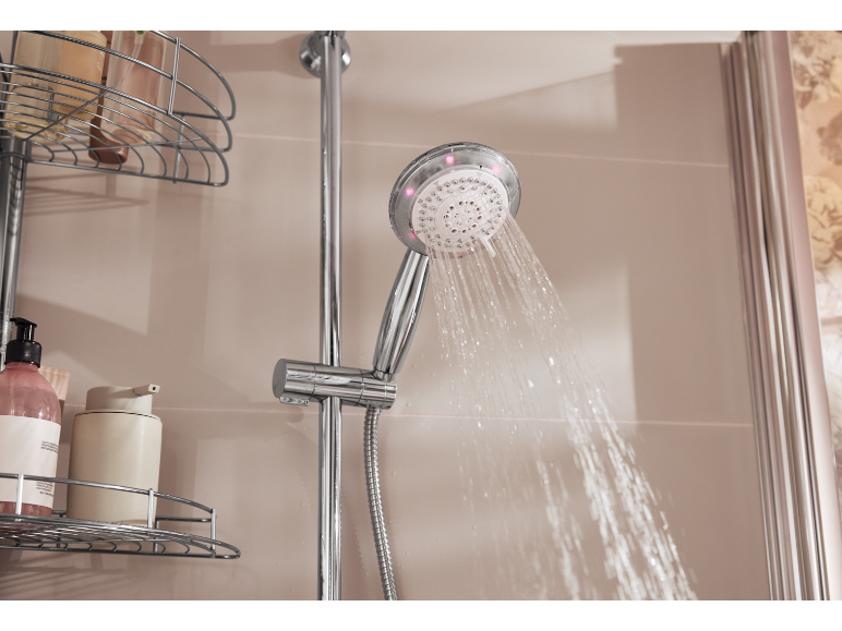 Duschkopf mit Wasserstrahl und Duschregal mit Flaschen.