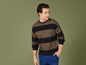 Mann in einem schwarz-gold gestreiften Pullover mit blauen Jeans.