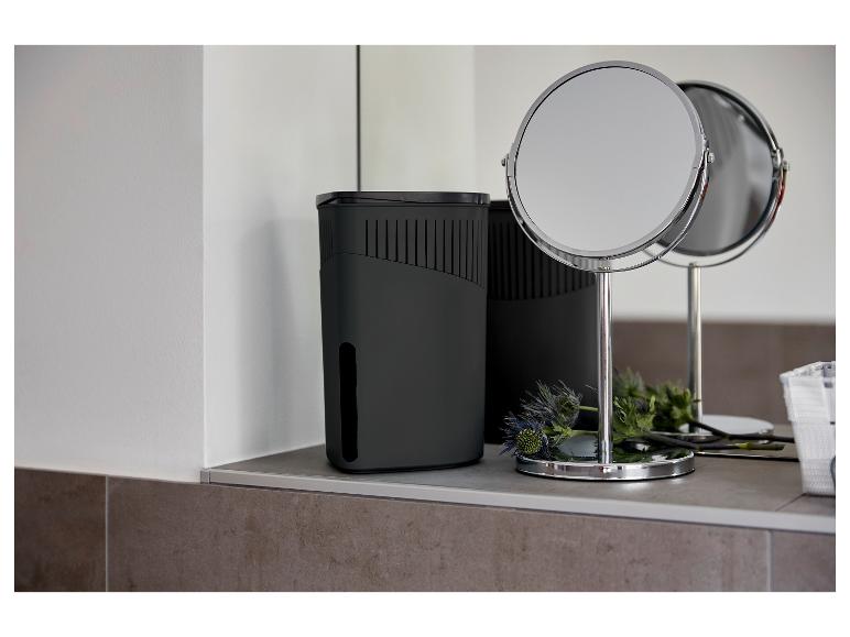 Ein schwarzer Luftentfeuchter und ein Tischspiegel in einem modernen Badezimmer.