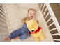 Lächelndes Baby im Kinderbett mit Plüschtier.