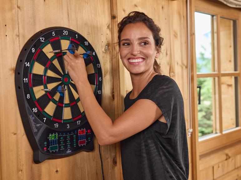 Eine Frau wirft Pfeile auf ein elektronisches Dartboard von Crivit.