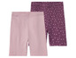 Zwei Paar Mädchen-Shorts, eine rosa und eine mit weißen Punkten auf lila Grund.