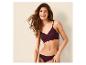 Lächelnde Frau in einem pflaumenfarbenen Bralette und passendem Slip.