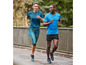 Zwei Personen laufen in Sportkleidung, darunter ein blaues T-Shirt und schwarze Shorts.