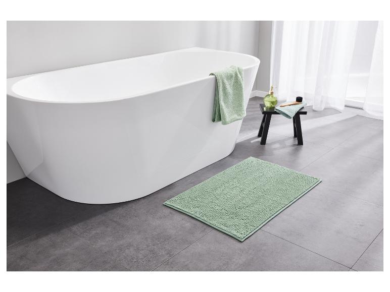 Hellgrüne Handtücher und Badematte in einem modernen Badezimmer.