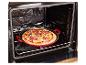 Frisch zubereitete Pizza in einer roten Backform, in einem offenen Ofen platziert.