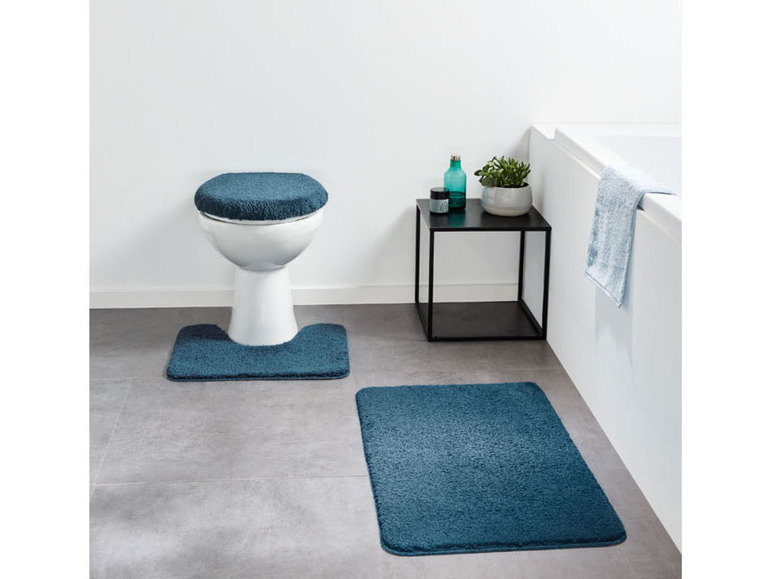 Badezimmer-Set mit dunkelblauem Toilettensitz und zwei Badematten.