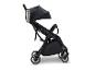 Schwarzer Kinderwagen mit Edelstahl-Getränkehalter auf weißem Hintergrund.