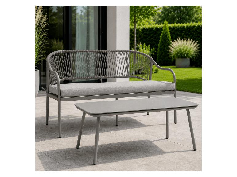 Graue Gartenbank mit Kissen und Couchtisch auf einer Terrasse.