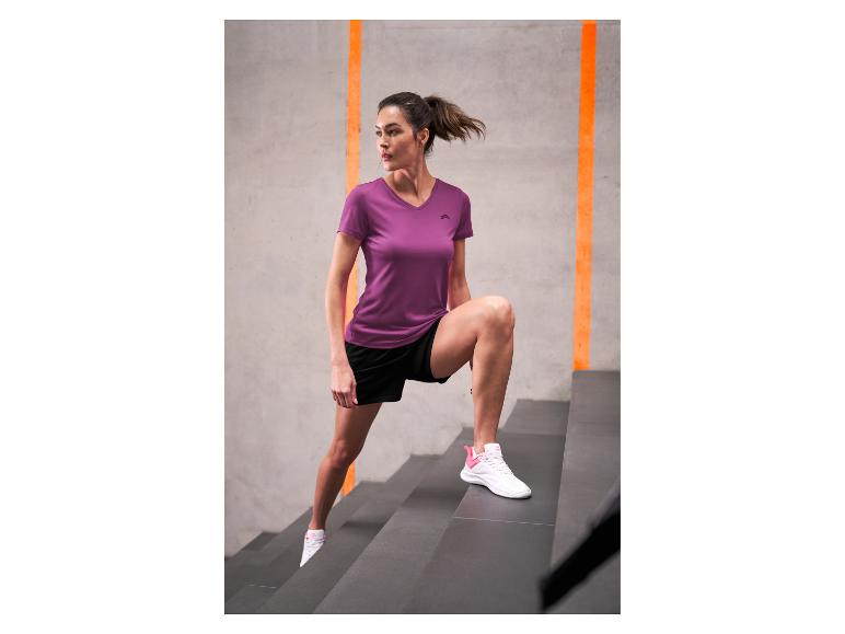Frau in lila Sport-T-Shirt und schwarzen Shorts trainiert auf Treppen.