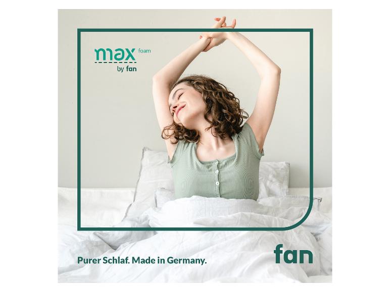 Lächelnde Frau im Bett mit „max foam by fan“-Logo und „Purer Schlaf. Made in Germany.“ Text.