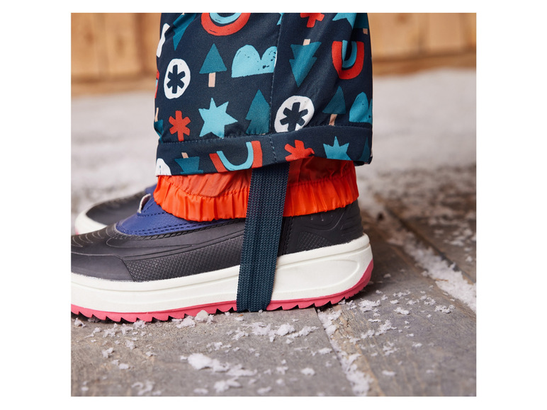 Ein Kinderschuh mit einer Regenhose mit lustigem Muster.