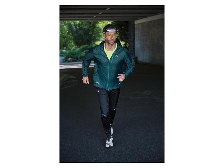 Mann läuft in Laufjacke, Hose und Stirnlampe.