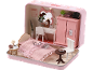 Ein Miniatur-Puppenhaus-Schlafzimmer in Rosa mit Bett, Schreibtisch, Kleiderschrank und kleinem Tisch.