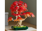 Künstlicher Bonsai-Baum mit roten und orangefarbenen Blättern in einem grünen Topf.