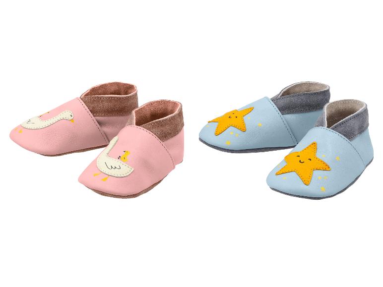 Zwei Paar Babyschuhe: rosa mit Gänsen und hellblau mit Sternen.