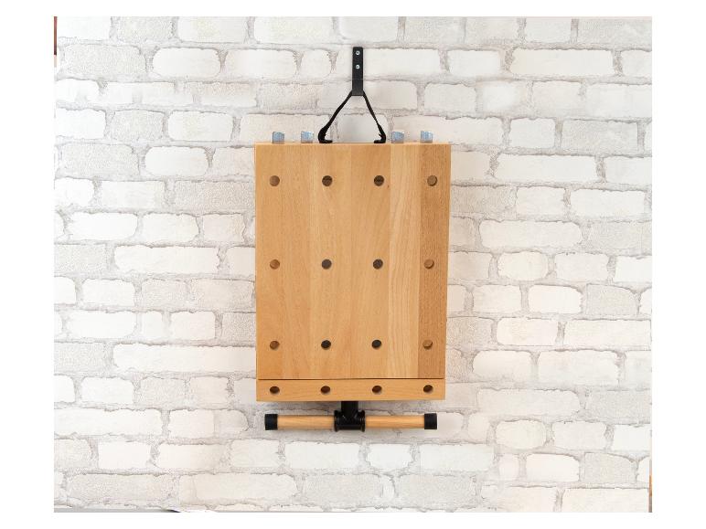 Holzwerkbank mit Schraubstock, an einer weißen Ziegelwand montiert.