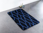 Eine blaue und schwarze Badematte mit geometrischem Muster.