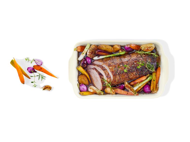 Gebratenes Fleisch mit Gemüse, darunter Kartoffeln, Karotten und Zwiebeln, serviert in einer Auflaufform.