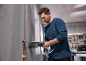 Ein Mann benutzt einen Akku-Rohrabschneider an einem Kupferrohr in einer Werkstatt.