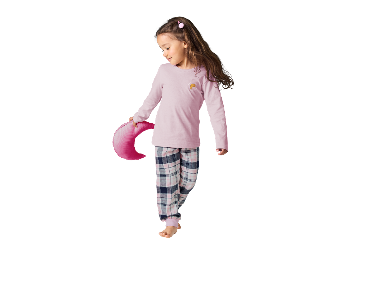 Kind im rosa karierten Pyjama, hält ein croissantförmiges Kissen.