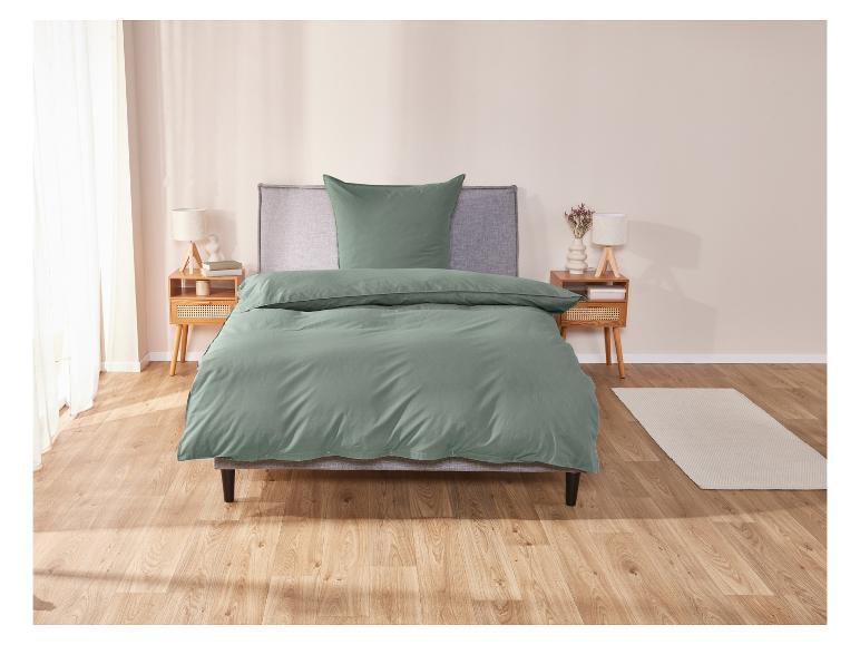 Ein Bett mit grüner Bettwäsche.