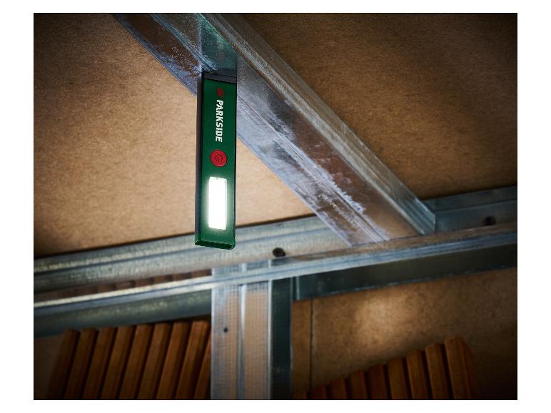 Parkside Taschenlampe an einem Metallträger befestigt, die eine Holzdecke beleuchtet.