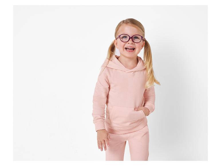 Ein junges Mädchen in einem rosa Hoodie und einer Hose.
