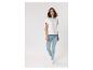 Frau in weißem T-Shirt und hellblauen Skinny Jeans, geht vorwärts.