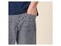 Mann in blauem T-Shirt und grauen Shorts mit der Hand in der Tasche.