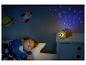 Ein Kind schläft in einem Bett mit einem Schildkröten-Nachtlichtprojektor, der Sterne und Monde projiziert.