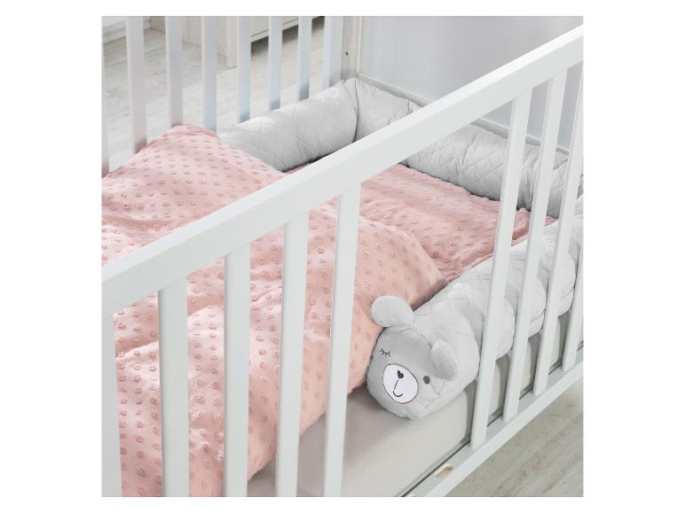 Weißes Babybett mit rosa Bettwäsche und grauem Bären-Bettnestchen.
