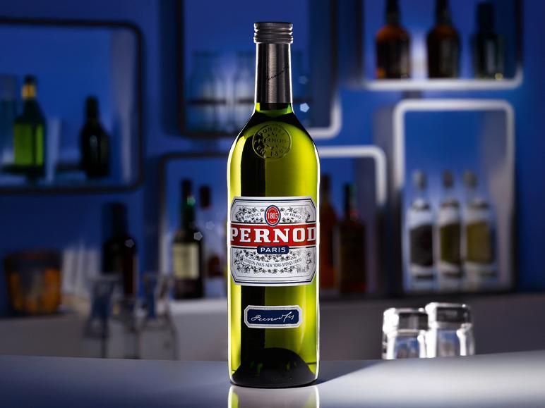Flasche Anis-Aperitif auf einer Bartheke mit unscharfen Flaschen im Hintergrund.