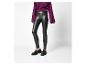 Frau in violetter Bluse, schwarzen Lederleggings und schwarzen Loafern.