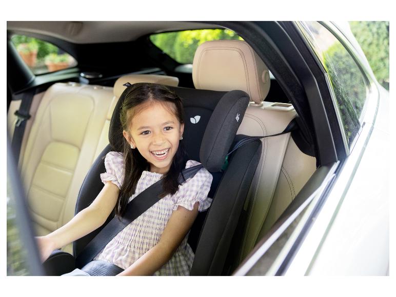 Lächelndes Mädchen in einem Kindersitz auf dem Rücksitz eines Autos.