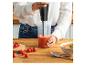 Frau püriert Tomatensuppe mit einem Stabmixer, mit frischen Tomaten und Salz.