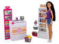 Eine Barbie-Puppe an einem Spielzeugladen mit Kasse, Waage und Lebensmittelbereich.