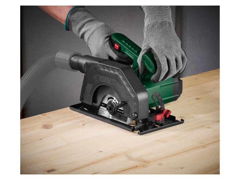 Eine Person mit Handschuhen benutzt eine Parkside Mini-Kreissäge auf einer Holzoberfläche.