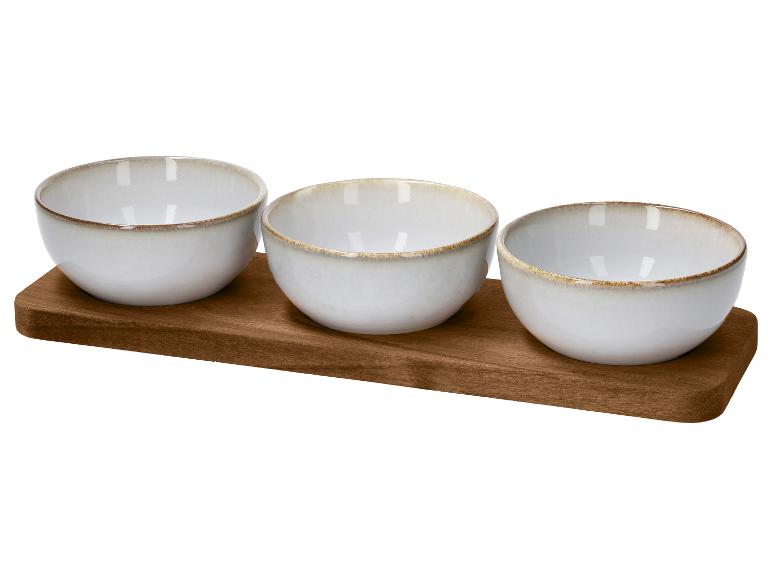 Drei weiße Keramikschalen auf einem Holztablett.