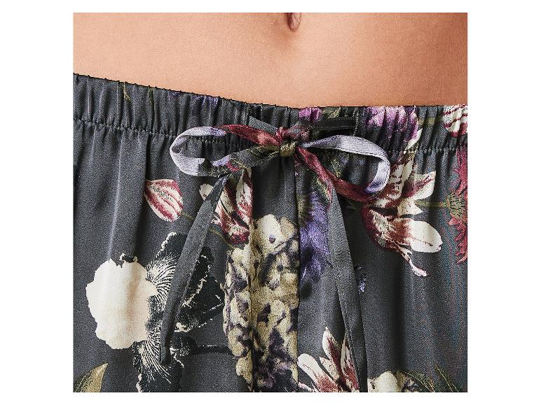 Nahaufnahme des Bauches einer Person in floral gemusterten Pyjamahosen mit Kordelzug.