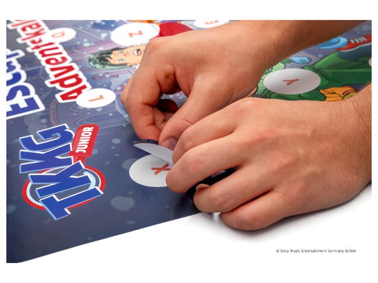 Hände öffnen ein Fenster auf einem TKKG Junior Adventskalender.