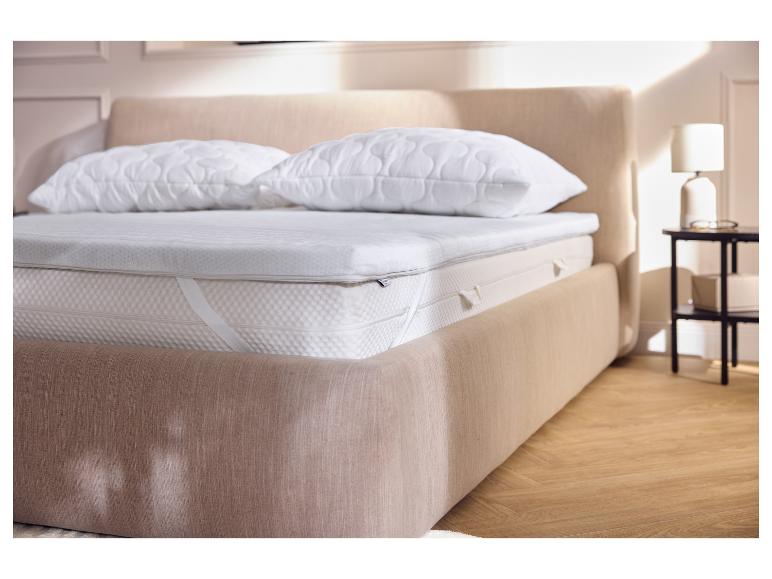 Schlafzimmer mit einem Bett mit Matratzenauflage, Matratze und zwei Kissen.