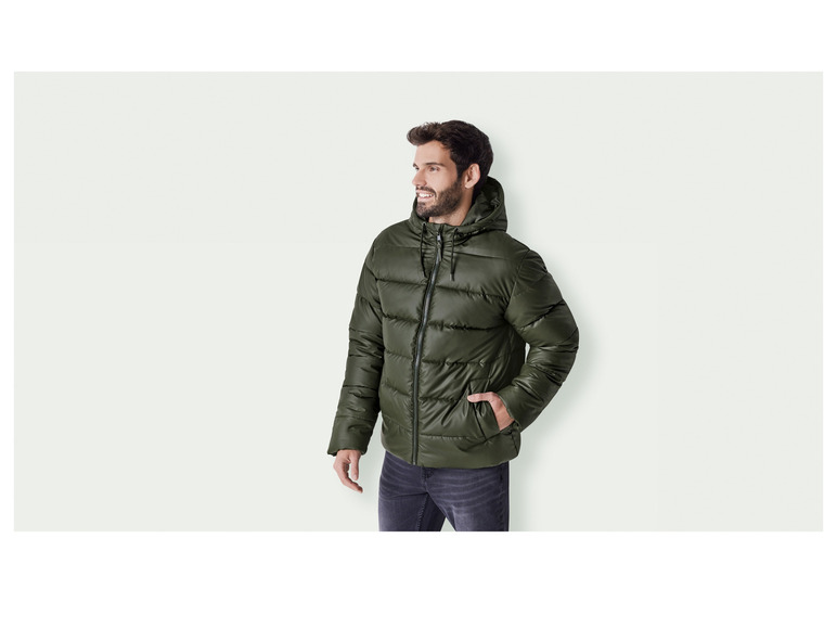 Ein Mann trägt eine grüne Daunenjacke mit Kapuze.